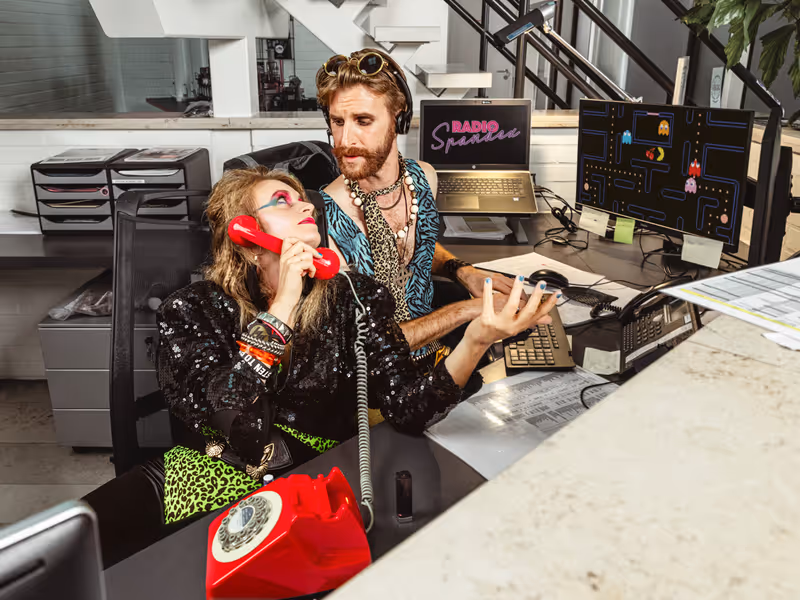 Twee bandleden van Radio Spandex in 80's outfit aan het onthaal: zangeres Blondie neemt op met een rode draaischijftelefoon. Foto: Michiel Devijver