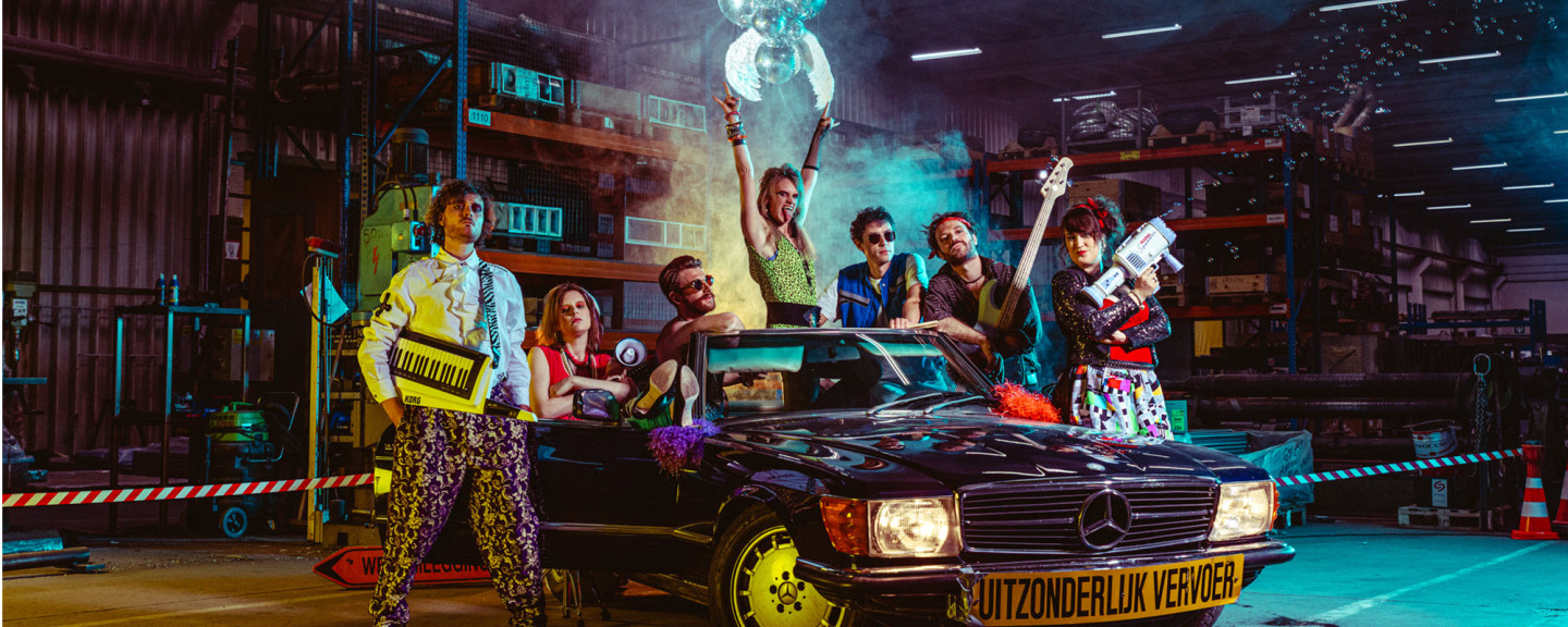 Group photo of 80's Cover Band Radio Spandex Members of 80s cover band Radio Spandex pose in front of a Mercedes oldtimer in a factory warehouse