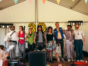 Radio Spandex ontvangt samen het applaus — © Michiel Devijver Members of 80's coverband Radio Spandex standing on stage, applauding with audience at the end of a birthday party performance. - Michiel Devijver Photography